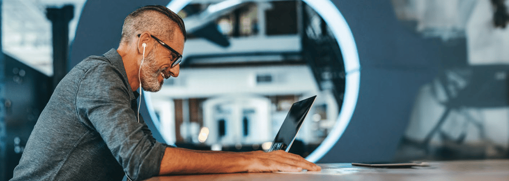 side profile of man working on laptop computer