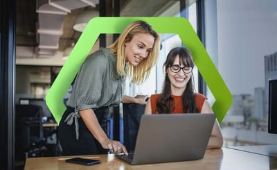 Two woman working together happily on a laptop