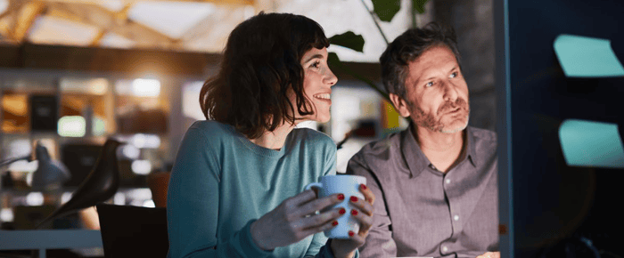 Male and female looking at computer screen and smiling