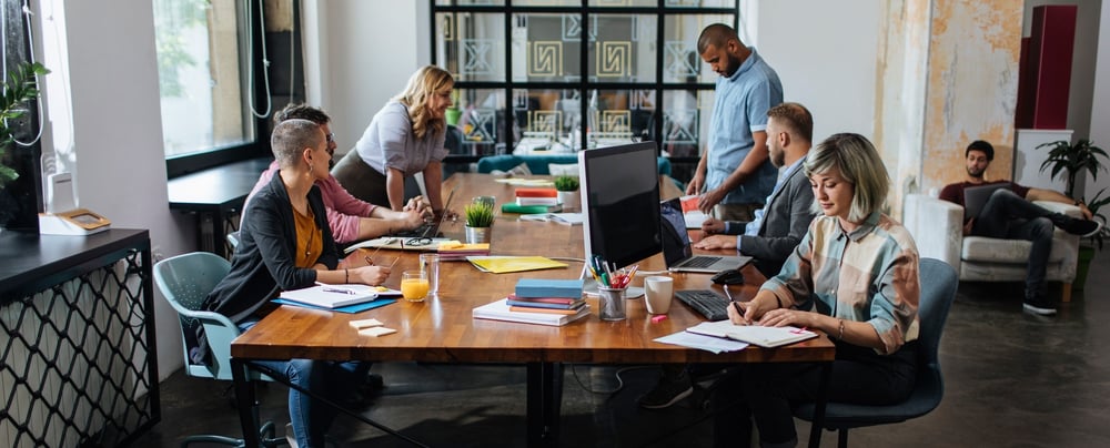 Men and woman at a conference table, working in an office