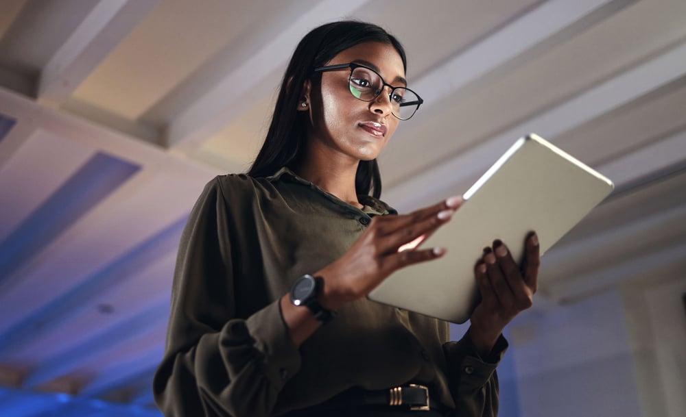 Woman with eyeglasses standing and ready from computer tablet
