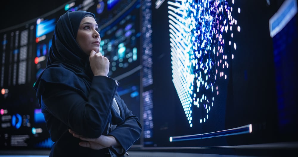 Woman looking at large wall computer screens