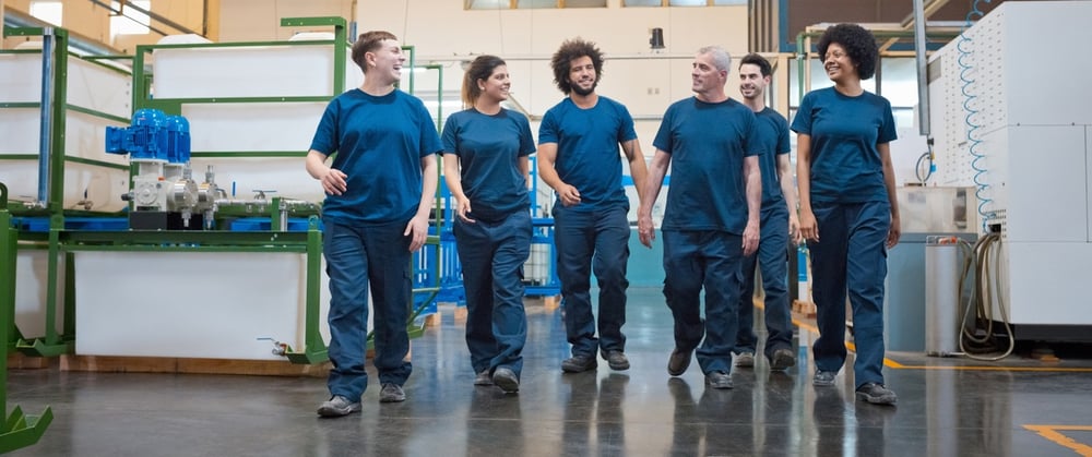 A group of employees walking through a warehouse A group of employees walking through a warehouse