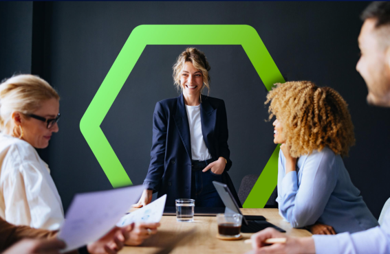 Woman standing at head of meeting table and smiling